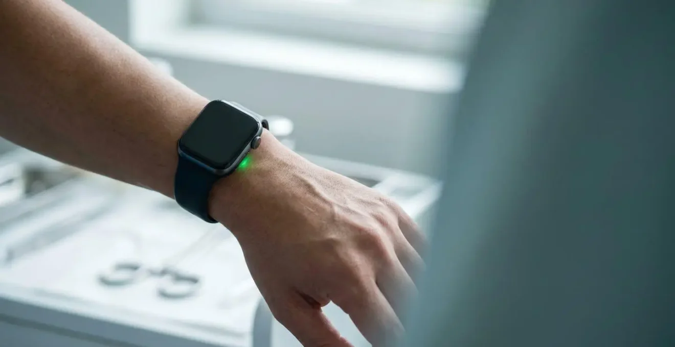 Close-up photograph of smartwatch optical sensor glowing on human wrist in soft natural lighting representing medical health monitoring technology