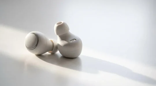 Close-up of true wireless earbuds with visible battery compartment showing degradation concepts
